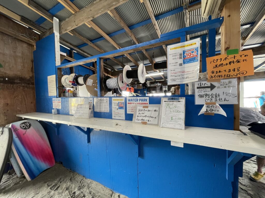 逗子ウォーターパークの受付カウンター。料金案内や貸出ボードが並ぶ